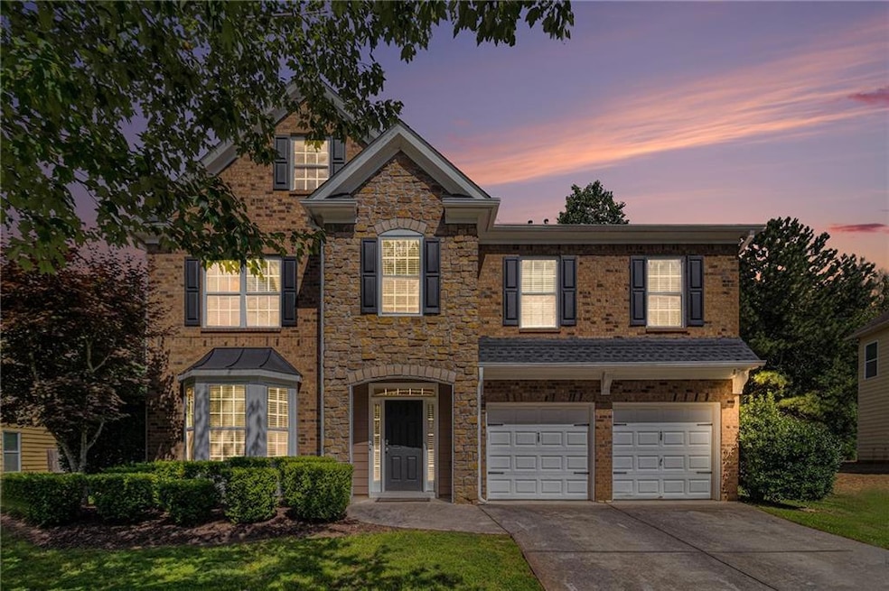 View of front of property with concrete driveway, an attached garage, and brick siding