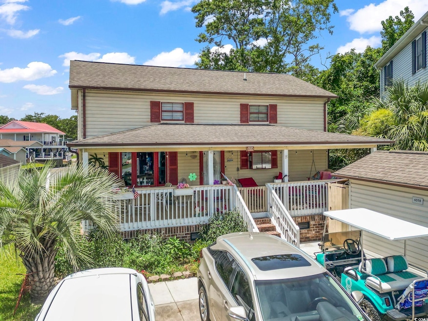 View of front of home with roof with shingles and covered porch