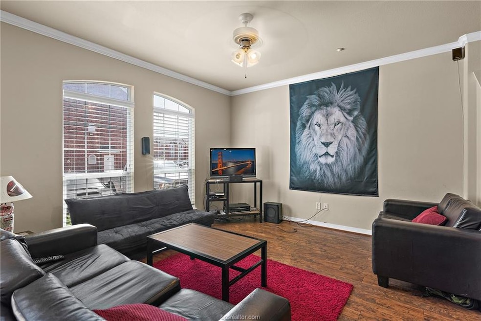Living area with wood finished floors, crown moldi