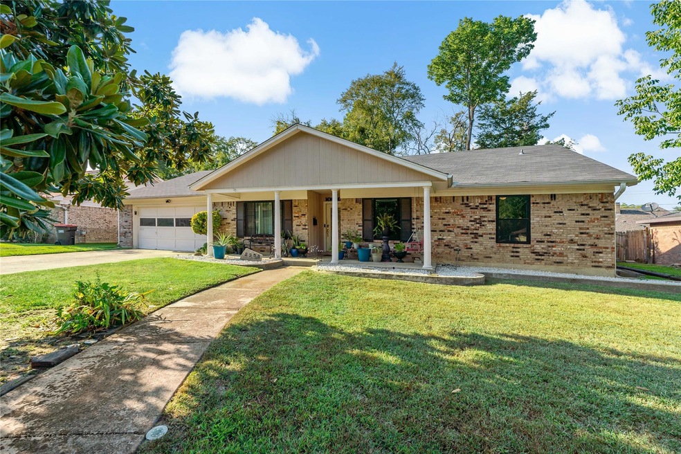 Ranch-style home featuring a garage and a front ya