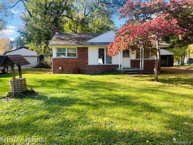 View of front of home with a front yard, brick siding, and a porch