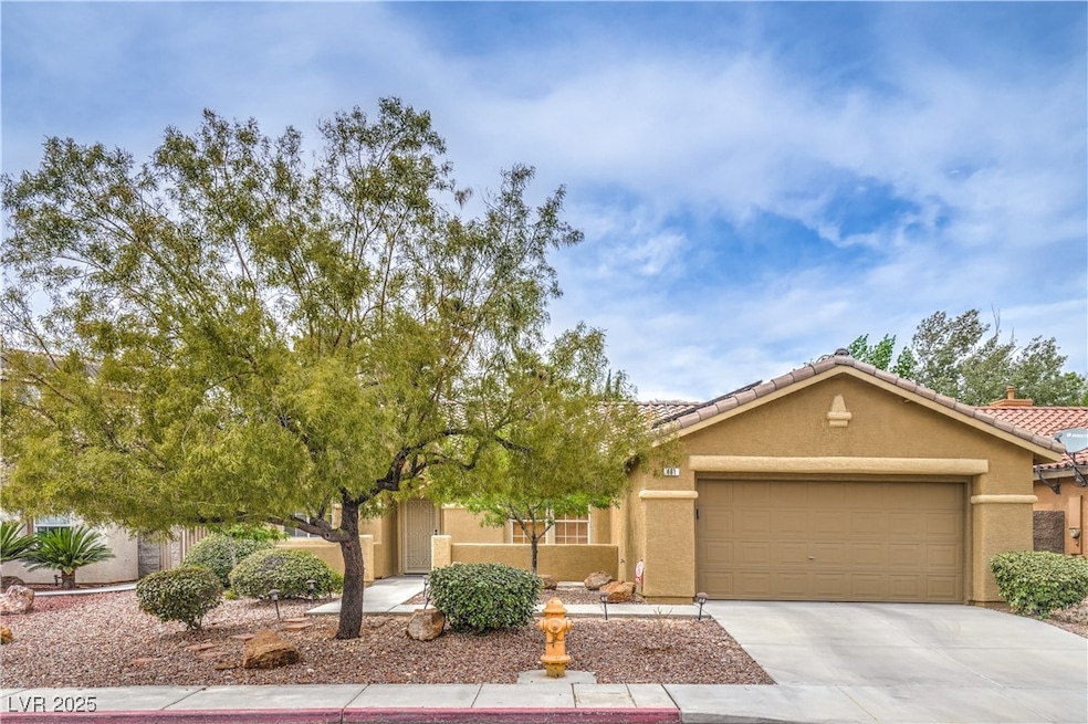 View of front of house featuring stucco siding, an attached garage, driveway, and a tiled roof