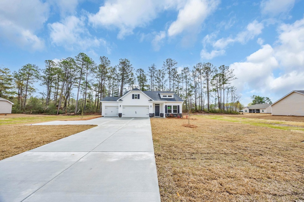 View of front facade with a front lawn, a garage, and driveway