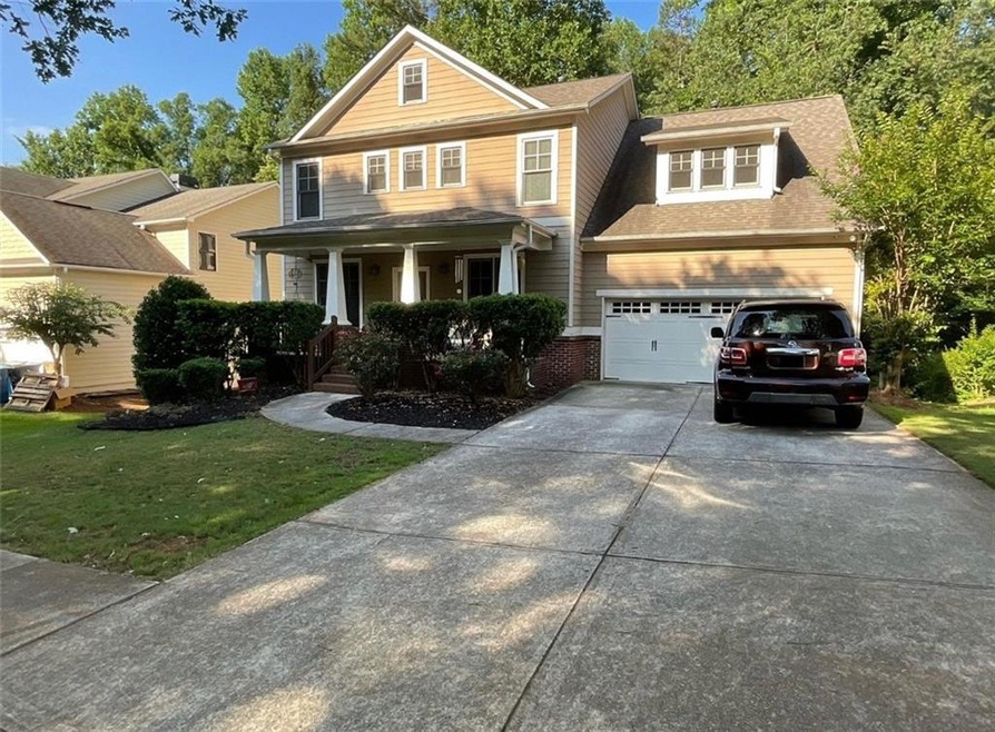 View of front of home featuring covered porch, a g