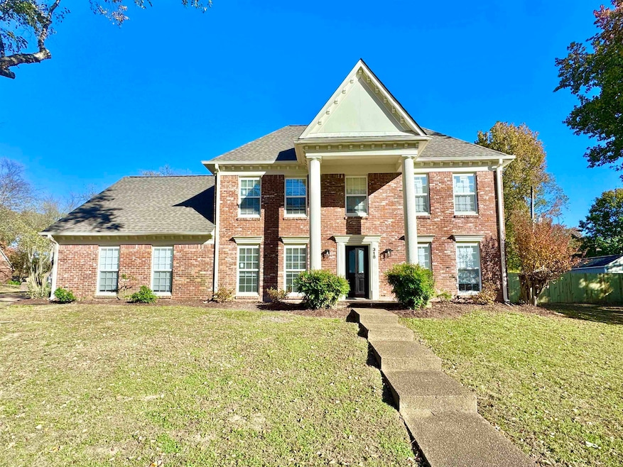 Neoclassical home with brick siding and a shingled roof