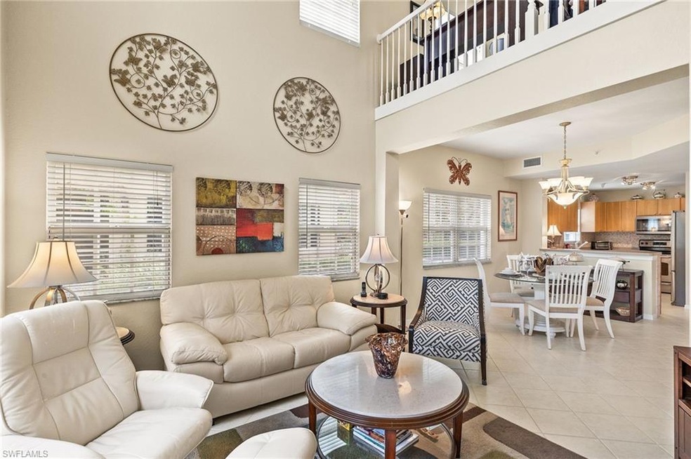 Tiled living room featuring a towering ceiling, a 