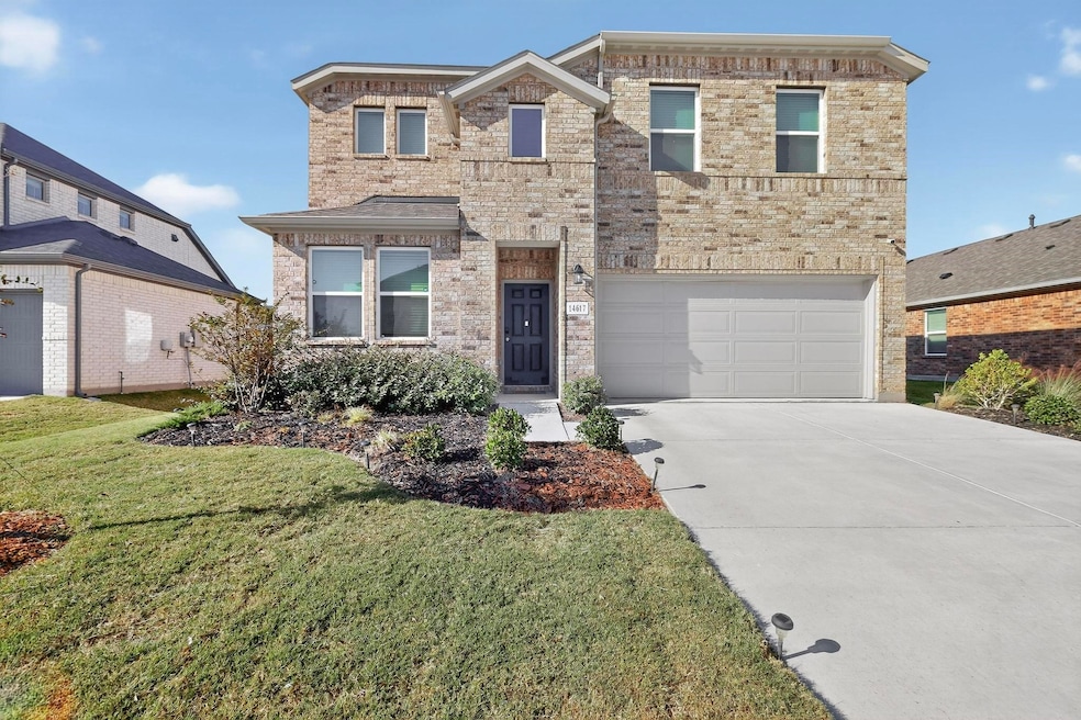 View of front of property with brick siding, concrete driveway, a front yard, and an attached garage