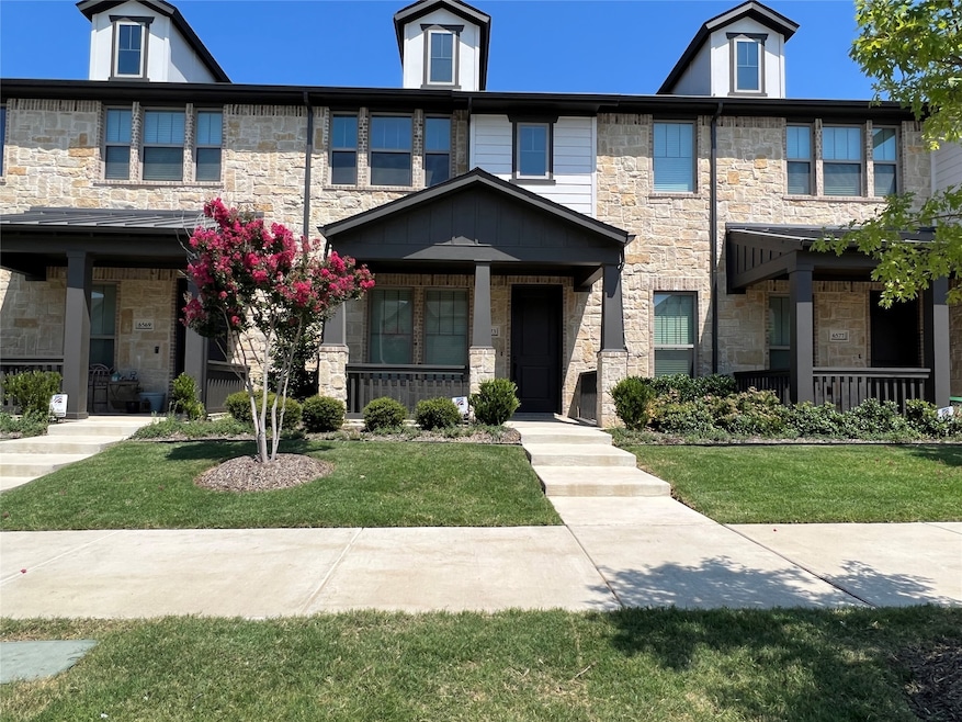 View of front facade featuring stone siding, covered porch, and a front yard