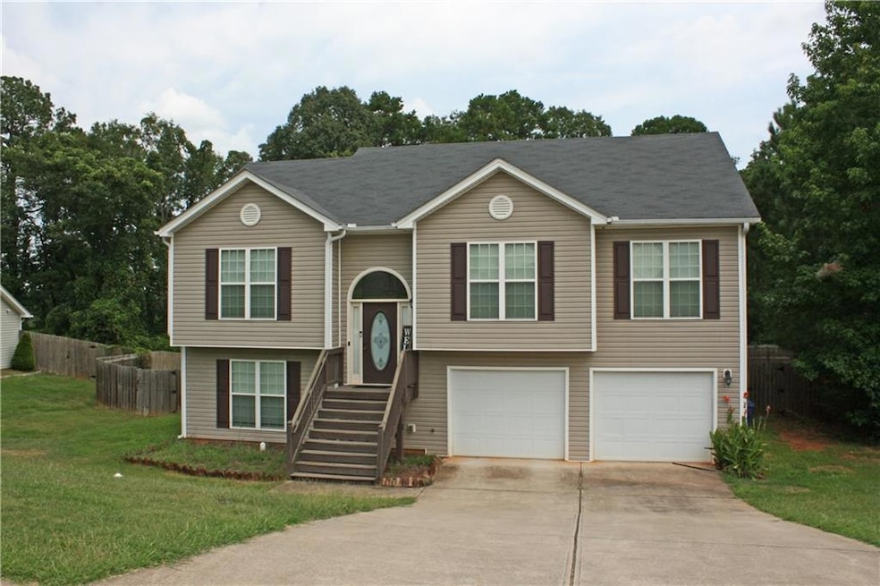 Split foyer home featuring a front lawn and a gara