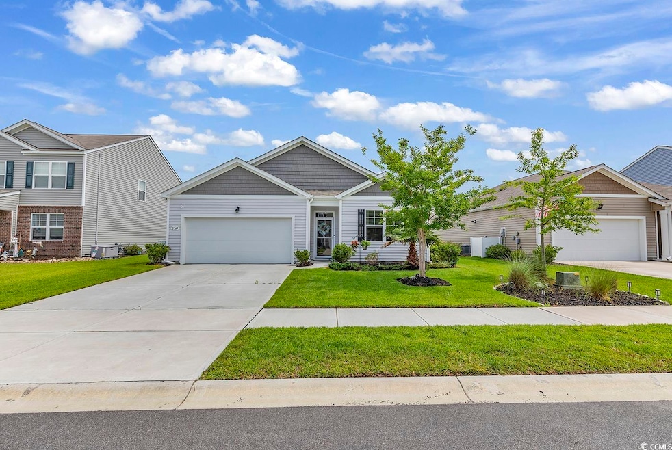 Craftsman house featuring driveway, an attached garage, and a front lawn