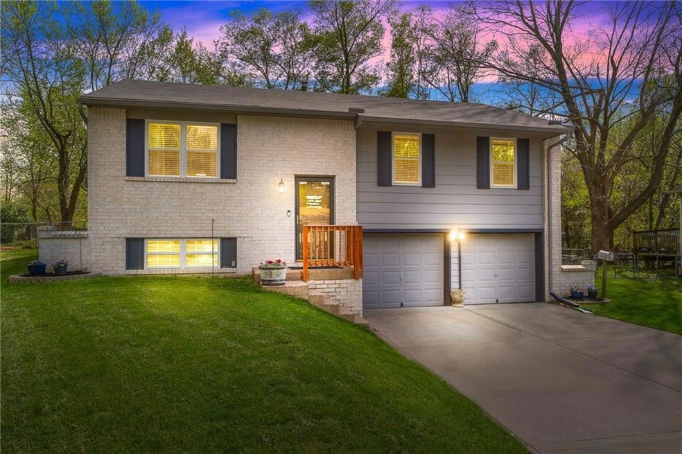 Raised ranch with a lawn and a garage