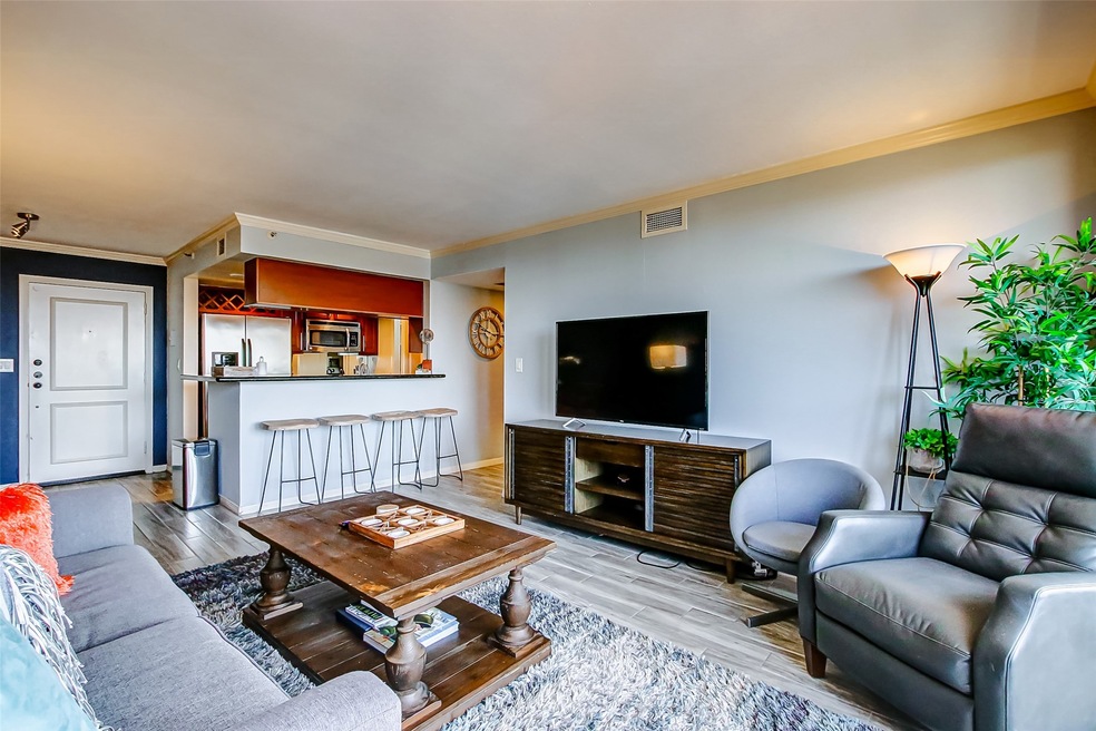 The cozy living room offers crown molding, wood-li