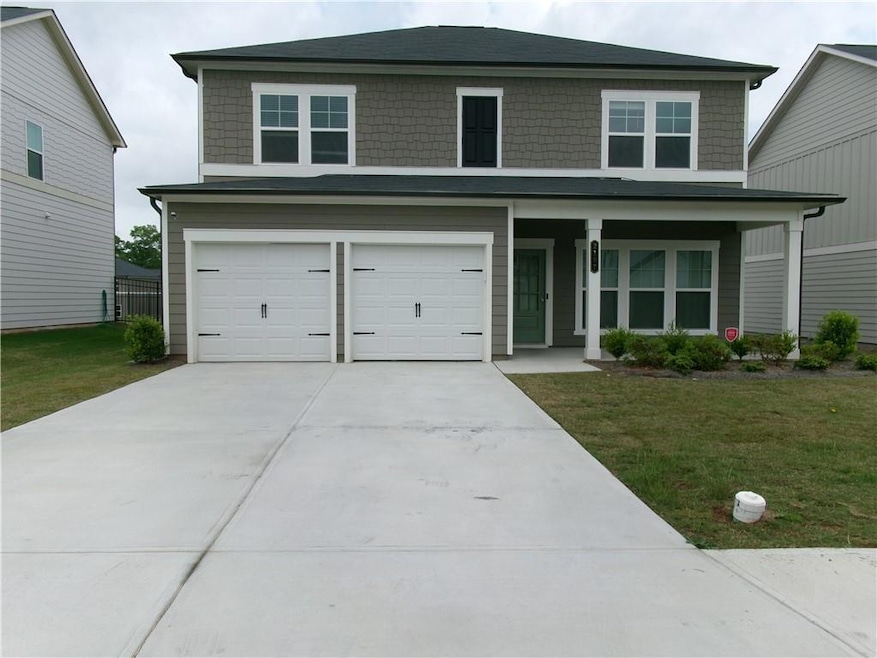 View of front of house with concrete driveway, a f