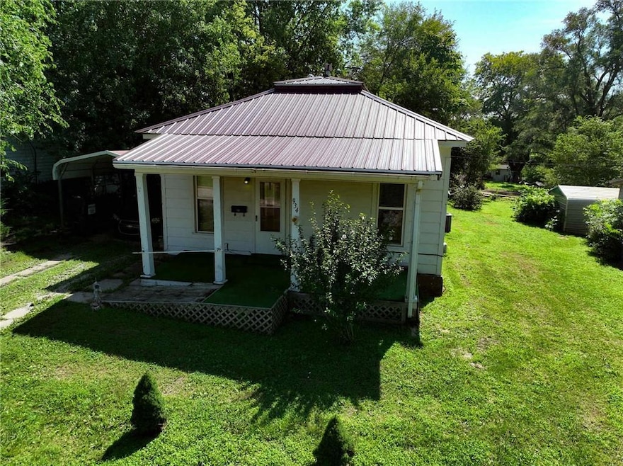 View of front facade with a front yard and a metal roof