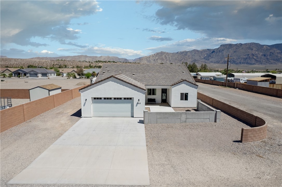 Single story home featuring a fenced front yard, driveway, a mountain view, and stucco siding