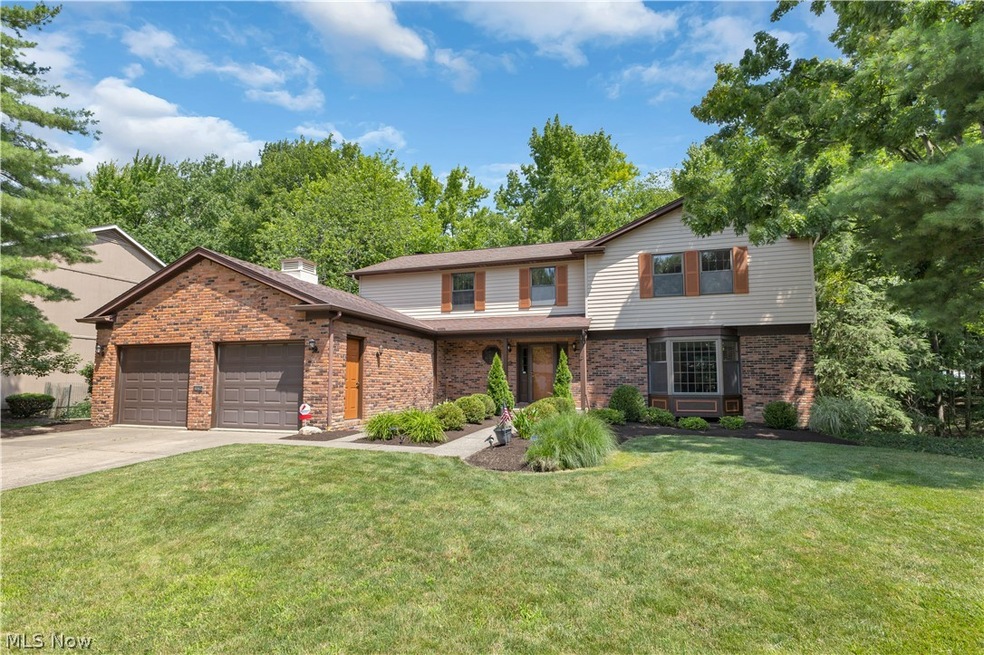 View of front property featuring a garage and a front lawn