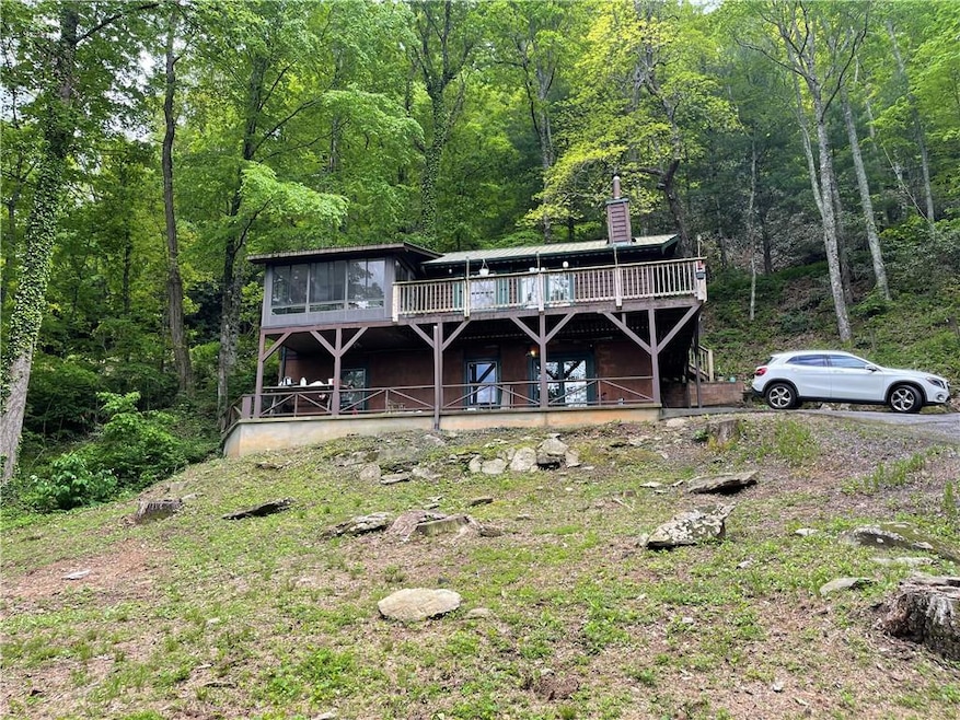 View of front facade with a forest view, a sunroom