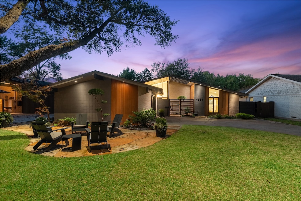View of front facade featuring a lawn, driveway, and a patio