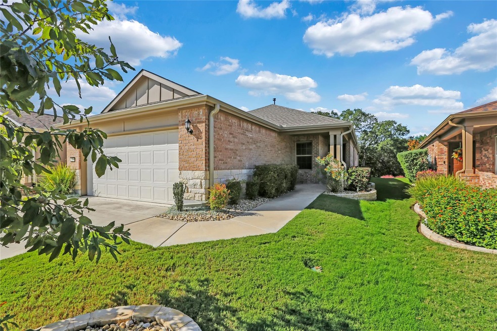 Ranch-style house with a garage, brick siding, concrete driveway, board and batten siding, and a front yard