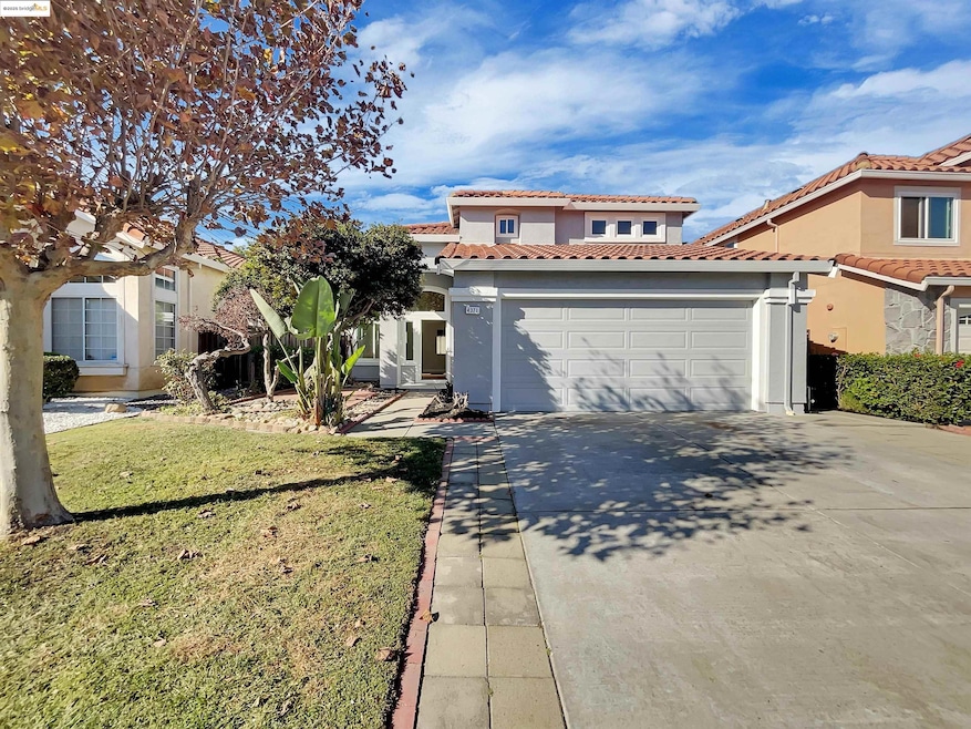 Mediterranean / spanish house with a tiled roof, stucco siding, driveway, and a front lawn