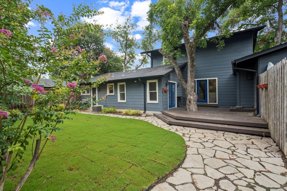 Rear view of property featuring a deck and a yard