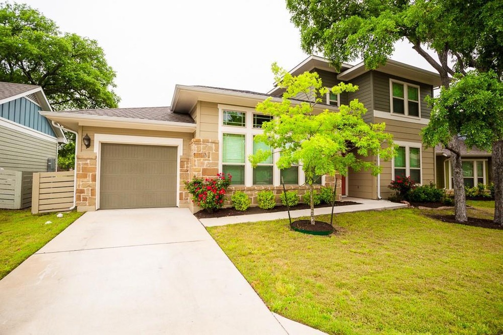 View of front of home with an attached garage, driveway, and a front yard