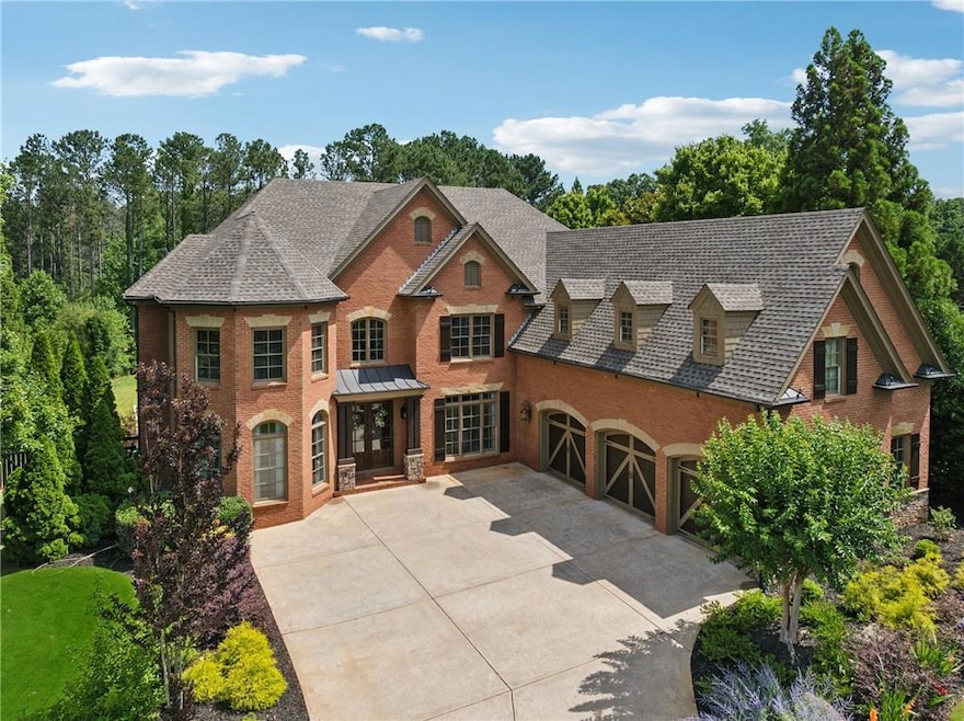 View of front of property with brick siding, concrete driveway, and roof with shingles