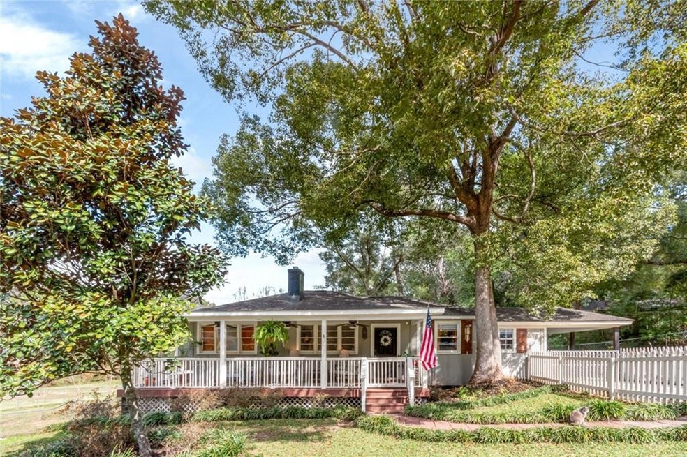 Single story home featuring covered porch, a chimn