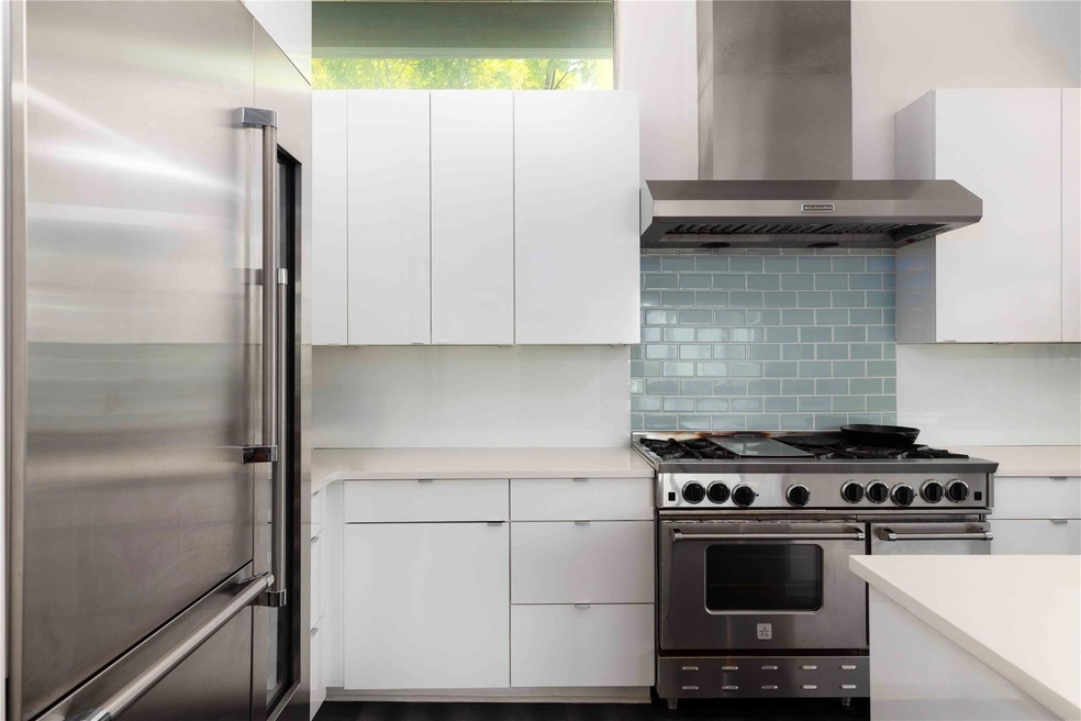 Kitchen featuring white cabinets, light counterto