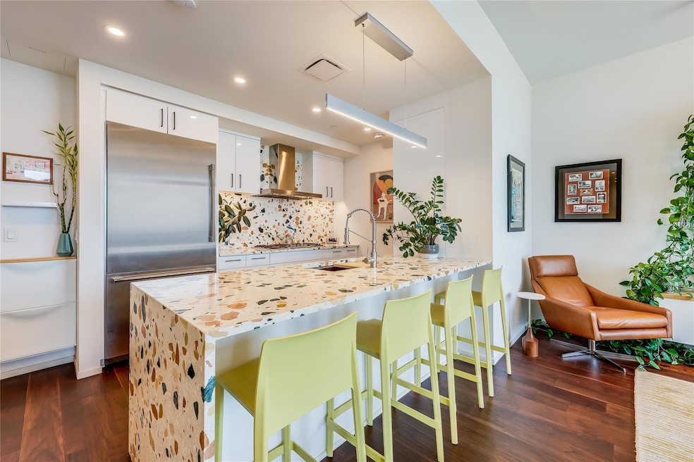 Kitchen featuring built in fridge, wall chimney e