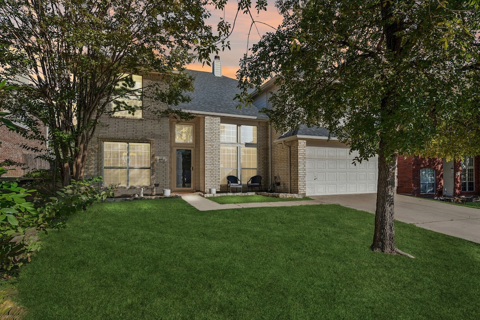 View of front facade with driveway, a yard, brick siding, and a garage