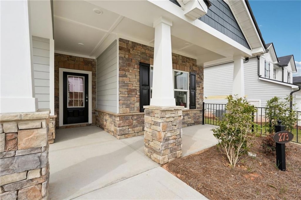 Entrance to property with a porch, fence, and ston