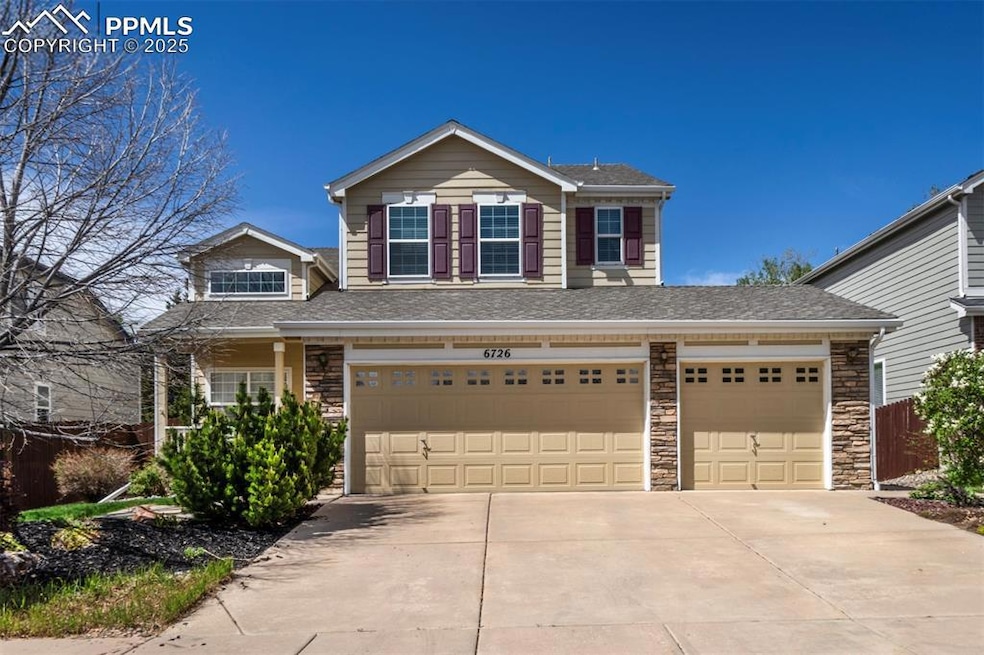 Traditional home with driveway, a garage, stone si