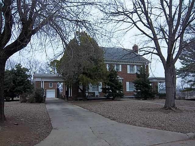Exterior Front. Concrete Drive with Portico and De