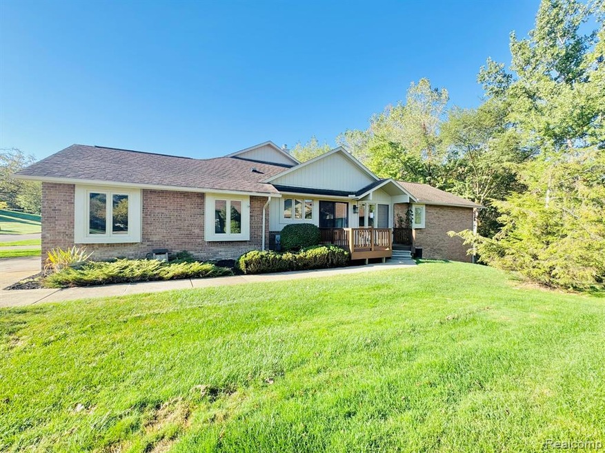 View of front of house with brick siding, a front lawn, a shingled roof, and a porch