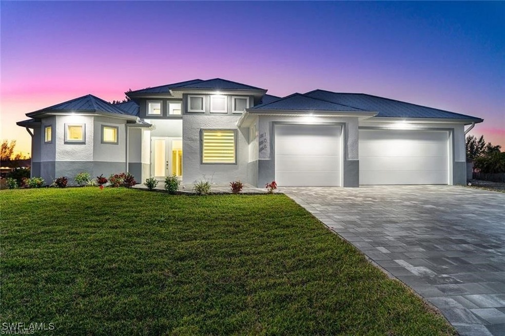 View of front facade featuring a garage and a yard