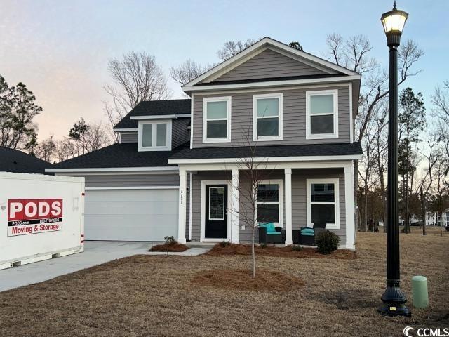 View of front of property with a garage and covere