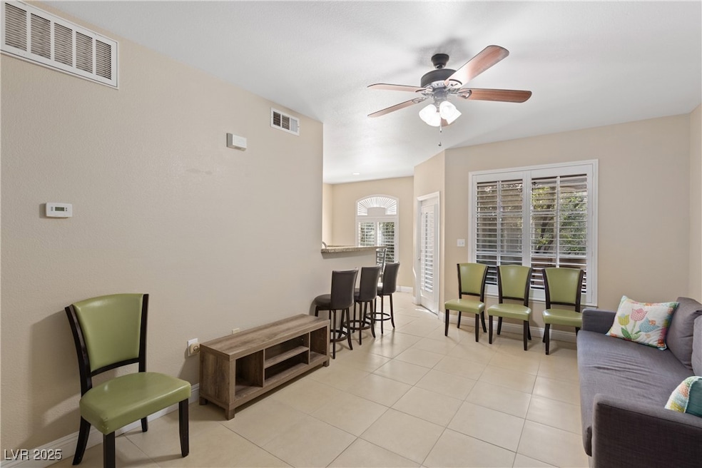 Living room featuring light tile patterned flooring and a ceiling fan