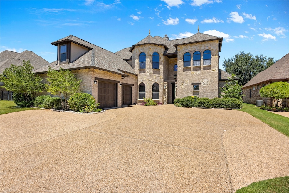 French provincial home with brick siding, driveway, and an attached garage
