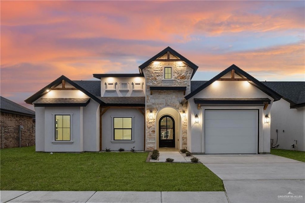 View of front of property featuring a garage and a yard