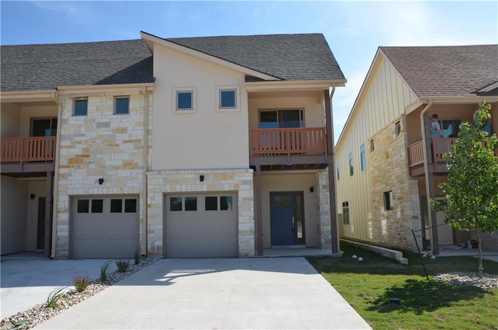Rear view of property with stone siding, driveway