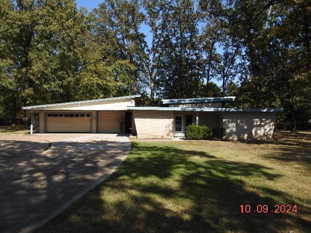 Ranch-style house with a garage and a front lawn