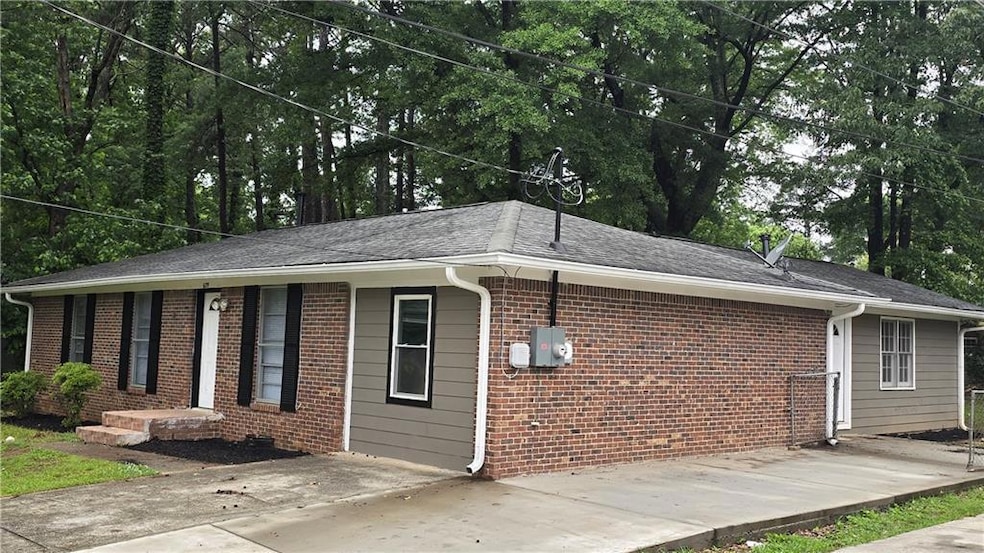 View of side of property featuring brick siding and a shingled roof