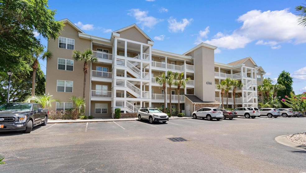 View of apartment building / complex with uncovered parking
