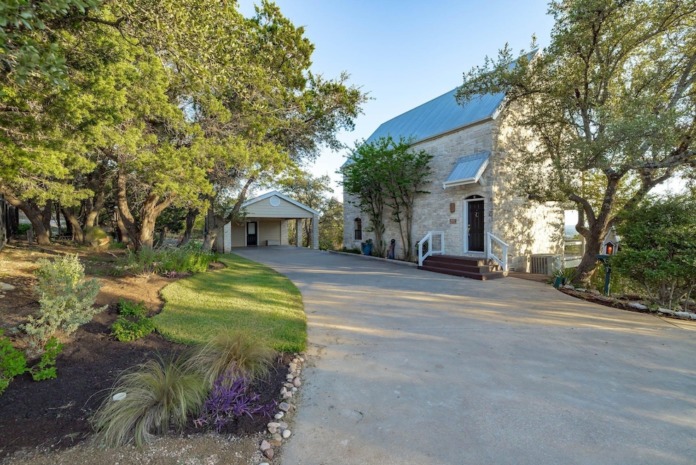 View of front facade featuring stone siding, driv