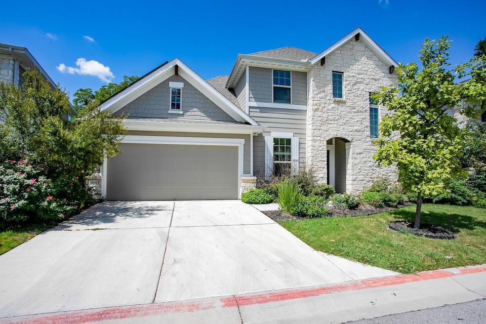 View of front of home with stone siding, driveway