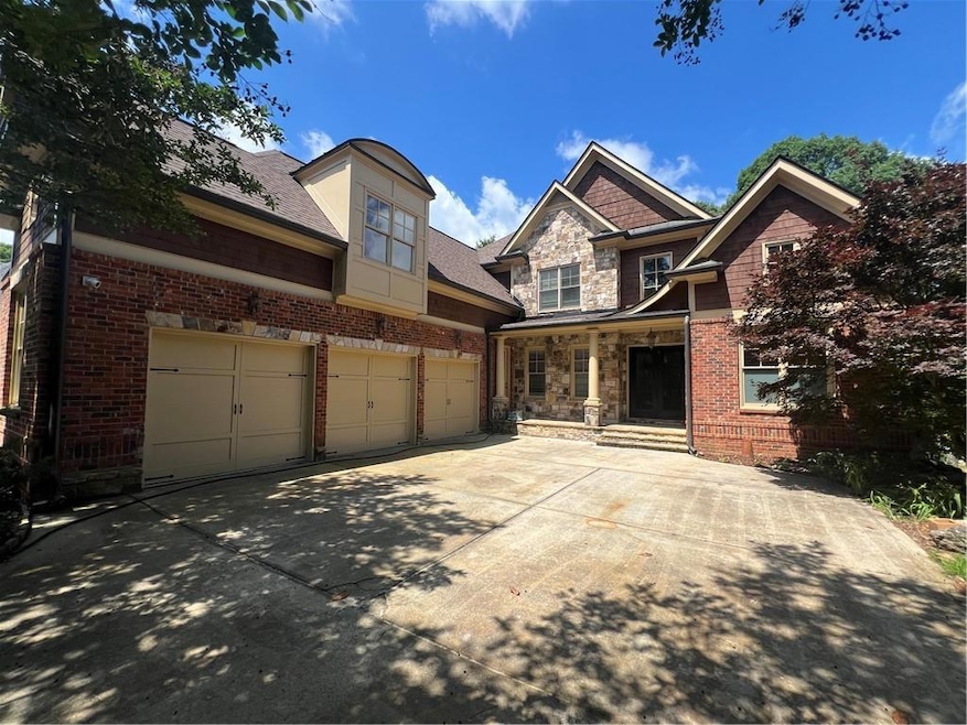 View of front of property with driveway, a porch, an attached garage, brick siding, and roof with shingles