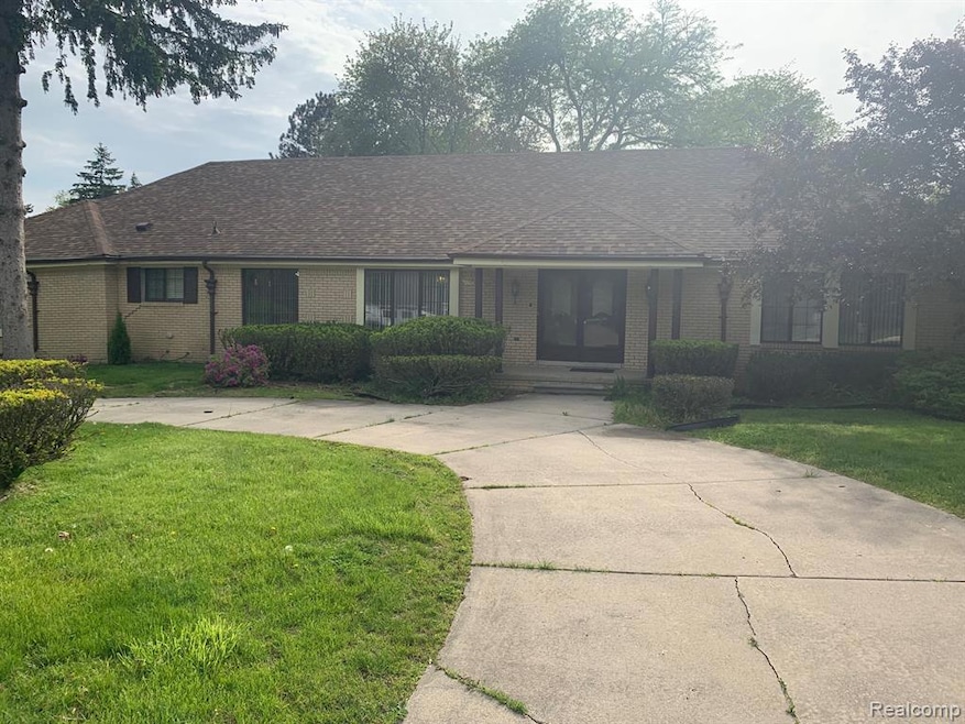Ranch-style house featuring a front yard, brick siding, and covered porch