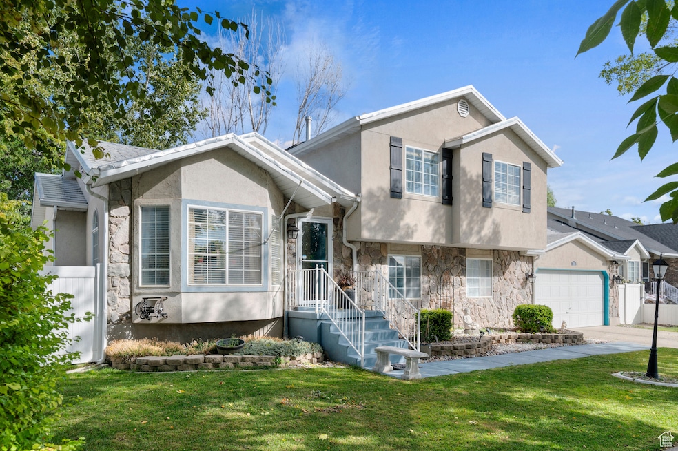 Split level home featuring stone siding and stucco siding