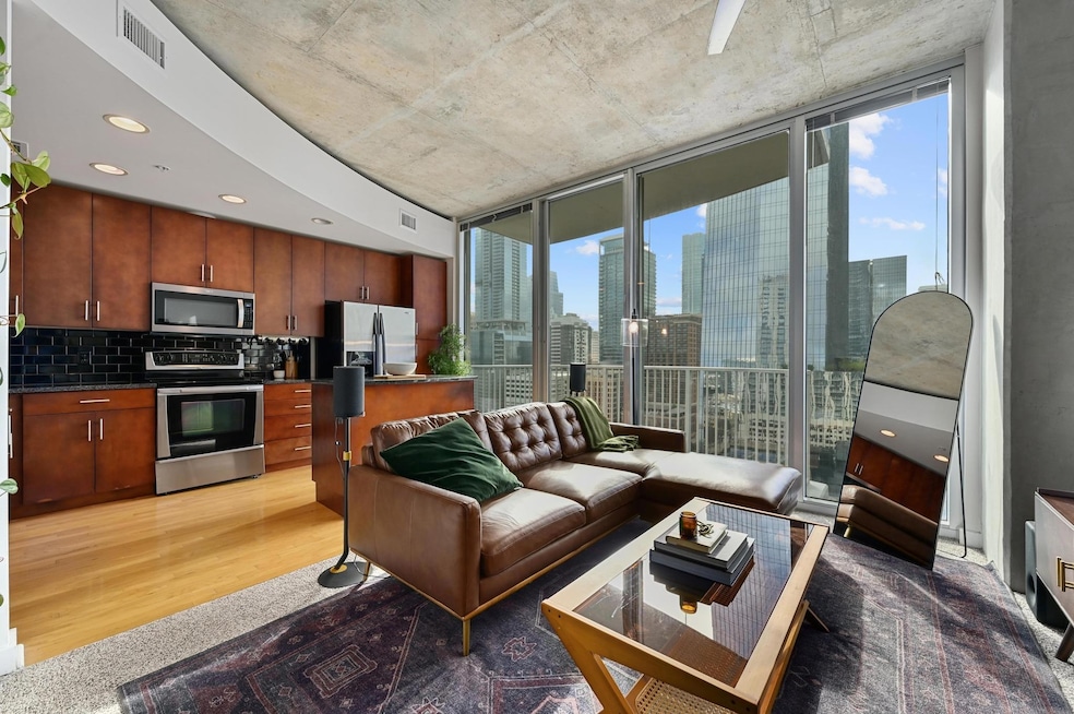 Living room with a wall of windows, light wood-st